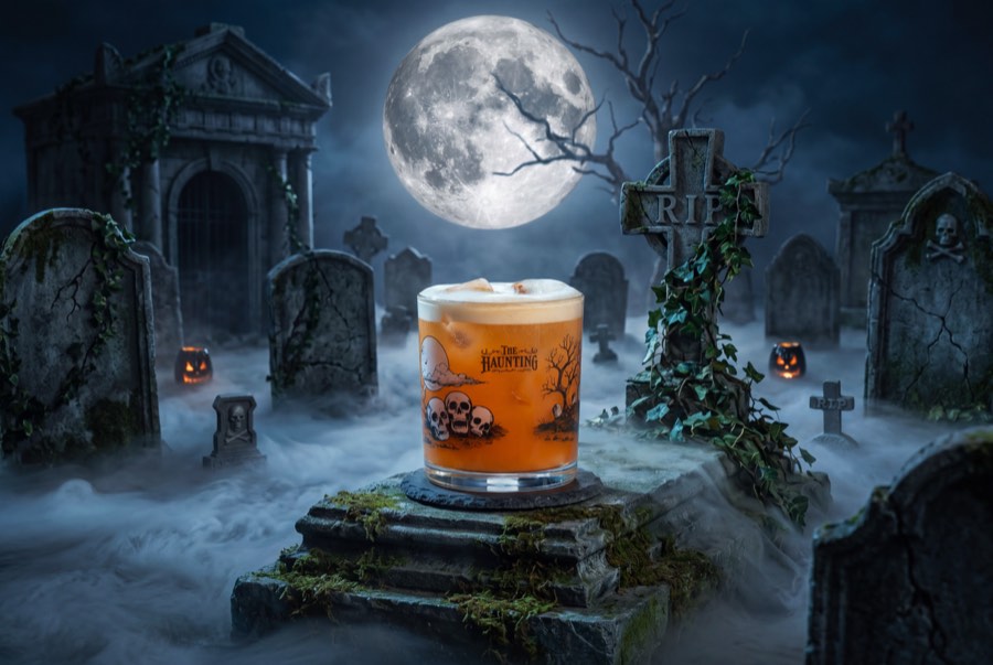A creamy orange drink in a graveyard scene beneath a full moon.